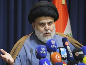 FILE - Populist Shiite cleric Muqtada al-Sadr, speaks during a mews conference in Najaf, Iraq, Thursday, Nov. 18, 2021. On Sunday, June 12, 2022, 73 lawmakers from the powerful cleric's bloc submitted their resignation based on his request, to protest a persisting political deadlock eight months after general elections were held.