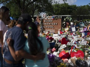 FILE - People visit a memorial at Robb Elementary School in Uvalde, Texas, on June 2, 2022, to pay their respects to the victims killed in a school shooting. A legislative committee investigating the deadly shooting at the Texas elementary school is set to hear more testimony from law enforcement officers on Monday, June 20, 2022.