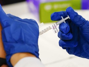 FILE - A health worker administers a dose of a Moderna COVID-19 vaccine during a vaccination clinic in Norristown, Pa. on Dec. 7, 2021. In a reversal for President Joe Biden, a federal appeals court in New Orleans on Monday, June 27, 2022, agreed to reconsider its own April ruling that allowed the administration to require federal employees to be vaccinated against COVID-19.