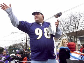 FILE - Tony Siragusa, defensive tackle for the Super Bowl-champion Baltimore Ravens, holds the Vince Lombardi trophy as he rides with his wife, Kathy, in a parade in his hometown of Kenilworth, N.J. on March 4, 2001. Siragusa, the charismatic defensive tackle who helped lead a stout Baltimore defense to a Super Bowl title, has died at age 55. Siragusa's broadcast agent, Jim Ornstein, confirmed the death Wednesday, June 22, 2022.