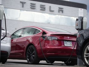 FILE - A 2021 Model 3 sedan is connected to a charger at a Tesla dealership on June 27, 2021, in Littleton, Colo. The National Highway Traffic Safety Administration said Thursday, June 9, 2022, that it's upgrading the probe into an engineering analysis, another sign of increased scrutiny of the electric vehicle maker and automated systems that perform at least some driving tasks.