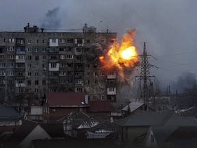 FILE - An explosion tears a hole in the side of an apartment building after a Russian tank fired a rocket in Mariupol, Ukraine, on March 11, 2022. Ukraine's parliamentary commission on human rights says Russia's military has destroyed almost 38,000 residential buildings, rendering about 220,000 people homeless, in the 100 days since its invasion of Ukraine.