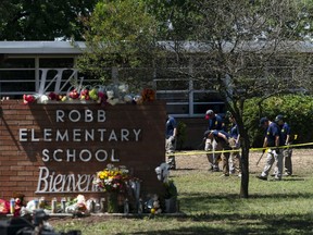 FILE - Investigators search for evidences outside Robb Elementary School in Uvalde, Texas, May 25, 2022, after an 18-year-old gunman killed 19 students and two teachers. The district's superintendent said Wednesday, June 22, that Chief Pete Arredondo, the Uvalde school district's police chief, has been put on leave following allegations that he erred in his response to the mass shooting.