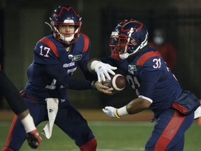 Montreal Alouettes quarterback Trevor Harris hands off to Alouettes running back William Stanback as they face the Ottawa Redblacks during first quarter CFL football action in Montreal on Friday, November 19, 2021.
