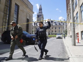 Police respond to an incident on Parliament Hill in Ottawa on Saturday, June 11, 2022. Two organizers of a rally set to take place on Parliament Hill Saturday say they were arrested and released soon after by police for being wrongfully identified in connection to a bomb threat in the area.THE CANADIAN PRESS/ Patrick Doyle