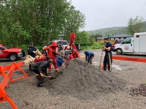 Residents and workers for the City of Fernie, B.C., fill sandbags in preparation for flooding along the Elk River. A flood warning along the waterway was lifted Tuesday but high water levels remain. THE CANADIAN PRESS/HO-City of Fernie **MANDATORY CREDIT**