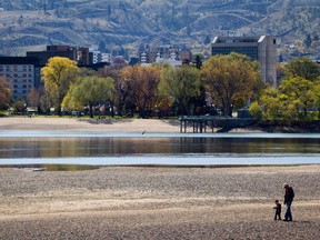 A man and young child walk along the north Thompson River in Kamloops B.C., on Monday, April 22, 2013. A flood watch has been issued for the south Thompson River in British Columbia, where a forecast calling for long-lasting rain means swollen waterways could overflow and cause flooding in some areas.THE CANADIAN PRESS/Darryl Dyck