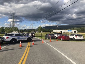 Law enforcement vehicles block the road at the scene of a shooting at a Maryland business near Smithsburg, Md., on Thursday June, 9 2022. A man opened fire at a manufacturing business in rural western Maryland on Thursday, killing multiple people before the suspect and a state trooper were wounded in a shootout, authorities said.