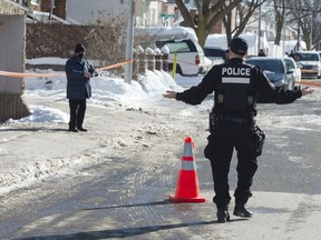 A police officer asks a man who wandered into a crime scene, where A 15-year-old girl was killed to leave, in Montreal, Monday, February 8, 2021.THE CANADIAN PRESS/Ryan Remiorz