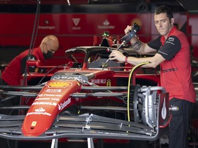 Ferrari mechanics work on the car of Carlos Sainz at the Canadian Grand Prix, Thursday, June 16, 2022, in Montreal.