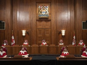 Justices of the Supreme Court pose for a photo sitting in the Supreme Court following a welcoming ceremony, Thursday, October 28, 2021 in Ottawa.