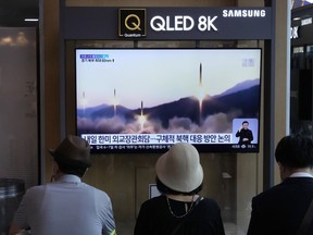 People watch a TV showing a file image of North Korea's missiles launch during a news program at the Seoul Railway Station in Seoul, South Korea, Monday, June 13, 2022. North Korea test-fired suspected artillery pieces into the sea on Sunday, South Korea's military said, days after North Korean leader Kim Jong Un called for greater defense capability to cope with outside threats.