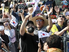 People watch the Nuri rocket, the first domestically produced space rocket, taking off from the launch pad near the Naro Space Center in Goheung, South Korea, Tuesday, June 21, 2022. South Korea launched its first domestically built space rocket on Tuesday in the country's second attempt, months after its earlier liftoff failed to place a payload into orbit.