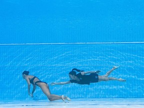 A coach recovers USA's Anita Alvarez (L), from the bottom of the pool when she fainted in the women's solo free artistic swimming finals, during the Budapest 2022 World Aquatics Championships.