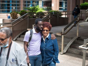 Desmond Cole and Beverly Bain, of the No Pride in Policing Coalition, share a hug before speaking to the media following the statements from Chief James Ramer of the Toronto Police Service regarding the 2020 race-based data, outside police headquarters in Toronto on Wednesday, June 15, 2022.