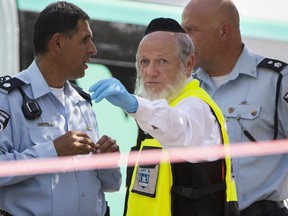 FILE - Yehuda Meshi-Zahav, then head of Israel's ZAKA rescue service, center, stands at the scene of a shooting attack by a Palestinian gunman, in Jerusalem on Oct. 13, 2015. Meshi-Zahav, a prominent member of Israel's ultra-Orthodox community who long served as a symbol of coexistence before his reputation came crashing down in a series of sexual abuse allegations, has died. Jerusalem's Herzog Medical Center confirmed his death on Wednesday, June 29, 2022, but did not give a cause. He was 62.