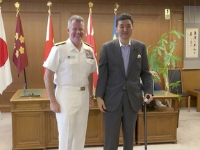 In this image made from a video, U.S. Pacific Fleet commander Adm. Sam Paparo, left, and Japanese Defense Minister Nobuo Kishi pose for media at the Defense Ministry in Tokyo, Friday, June 24, 2022. The U.S. Navy's top commander in the Pacific and the Japanese defense minister on Friday said close cooperation between their naval forces is more important than ever amid rising tensions over China, North Korea and Russia. (AP Photo)
