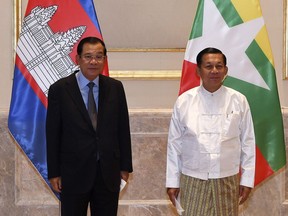 FILE - In this photo provided by An Khoun Sam Aun/National Television of Cambodia, Cambodian Prime Minister Hun Sen, left, poses for photographs together with Myanmar State Administration Council Chairman, Senior General Min Aung Hlaing, right, before holding a meeting in Naypyitaw, Myanmar, on Jan. 7, 2022. Hun Sen has urged military-ruled Myanmar to reconsider the death sentences given four political opponents, suggesting that executing them will draw strong international condemnation and complicate efforts to restore peace to the strife-torn nation.(An Khoun SamAun/National Television of Cambodia via AP, File)