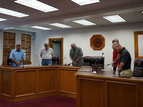 Uvalde Mayor Don McLaughlin, Jr., center, and members of the city council pray during a special emergency city council meeting, Tuesday, June 7, 2022, in Uvalde, Texas, to reissue the mayor's declaration of a local state of disaster due to the recent school shooting at Robb Elementary School. Two teachers and 19 students were killed.