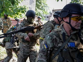 Members of foreign volunteers unit which fights in the Ukrainian army walk, as Russia's attack on Ukraine continues, in Sievierodonetsk, Luhansk region Ukraine June 2, 2022. Picture taken June 2, 2022.  REUTERS/Serhii Nuzhnenko