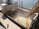Ein Werftarbeiter sieht zu, wie Gerstenkorn am 9. Juli 2013 am Versandterminal eines ukrainischen Agrarexporteurs in der südukrainischen Stadt Nikolaev mechanisch in ein 40.000-Tonnen-Schiff gegossen wird.