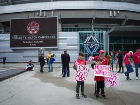 Young fans hold signs and make a thumbs-down gesture outside B.C. Place stadium after the Canadian national men's soccer team's friendly match against Panama was cancelled due to a labour dispute, in Vancouver, on Sunday, June 5, 2022.&ampnbsp;Experts say the well of goodwill created by the on-field success of Canada's soccer teams in recent months is quickly drying up amid a heated contract dispute between the men's national squad and Canada Soccer, the sport's national governing body.&ampnbsp;THE CANADIAN PRESS/Darryl Dyck