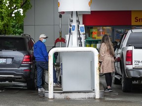 People fuel up vehicles at a Shell gas station after the price of a litre of regular grade gasoline reached a new high of $2.28, in Vancouver, on Saturday, May 14, 2022. Canada's new emissions standards for gasoline and diesel will allow oil companies that get a federal tax break for installing carbon capture and storage systems to generate credits based on those systems, which they can then sell to refineries and fuel importers.