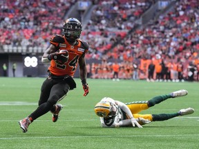 B.C. Lions' James Butler, left, gets away from a tackle by Edmonton Elks' Trey Hoskins and runs the ball in for his first touchdown during the first half of CFL football game in Vancouver, on Saturday, June 11, 2022.