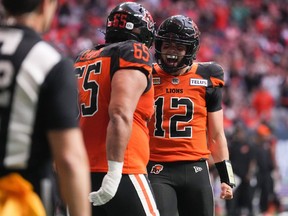 B.C. Lions quarterback Nathan Rourke (12) and Sukh Chungh (65) celebrate after Rourke ran the ball for a touchdown during the first half of CFL football game against the Edmonton Elks in Vancouver on June 11, 2022.