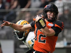 B.C. Lions quarterback Nathan Rourke (12) is pushed out of bounds by Edmonton Elks' Jalen Collins as he runs with the ball during the first half of CFL football game in Vancouver, on Saturday, June 11, 2022.