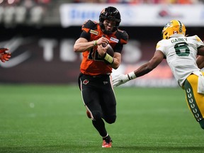 B.C. Lions quarterback Nathan Rourke, centre, runs past Edmonton Elks' Ed Gainey (6) on his way to scoring a touchdown during the second half of CFL football game in Vancouver, on Saturday, June 11, 2022.