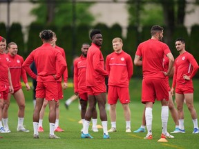 Canadian national men's soccer team forward Alphonso Davies, centre, stands with his teammates during a training session for a CONCACAF Nations League match against Curacao in Vancouver on Tuesday, June 7, 2022.&ampnbsp;After a drama-filled week away from the field, Canada's men's soccer team will finally take the field in front of hometown fans again tonight.