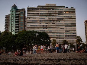 People gather at English Bay Beach amidst a heat wave, in Vancouver, B.C., on Monday, June 21, 2021.