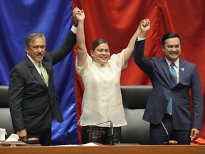 Vice-president-elect Sara Duterte, center, raises hands with Senate President Vicente Sotto III, left, and House Speaker Lord Allan Velasco during her proclamation at the House of Representatives, Quezon City, Philippines on Wednesday, May 25, 2022. Sara is the daughter of outgoing president Rodrigo Duterte.