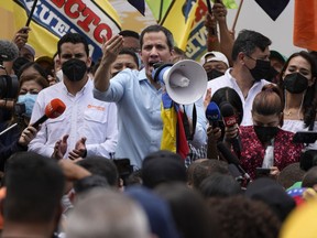 FILE - Opposition leader Juan Guaido, center, speaks to supporters during a gathering to mark Youth Day, in Caracas, Venezuela, Saturday, Feb. 12, 2022. Guaido was physically attacked Saturday, June 11 during a visit to a rural community, according to members of his parallel government, who accused a group of ruling party associates of carrying out the assault.