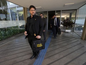 Federal police leave the headquarters of the Education Ministry after searching for evidence connected to the work of former Education Minister Milton Ribeiro in Brasilia, Brazil, Wednesday, June 22, 2022. Ribeiro was arrested on Wednesday in connection with a federal police corruption investigation.