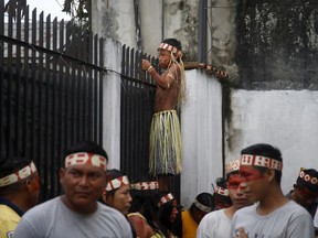 A Mayuruna Indigenous boy climbs a fence to look at the march against the disappearance of Indigenous expert Bruno Pereira and freelance British journalist Dom Phillips, in Atalaia do Norte, Vale do Javari, Amazonas, state Brazil, Monday, June 13, 2022. Brazilian police are still searching for Pereira and Phillips, who went missing in a remote area of Brazil's Amazon a week ago.