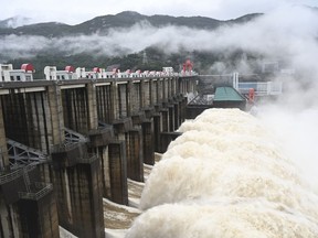 In this photo released by China's Xinhua News Agency, water flows out from a gate of the Shuikou Hydropower Station in southeastern China's Fujian Province, Monday, June 13, 2022. Heavy rain in China has claimed several lives this week and forced the evacuation of hundreds of thousands of people.