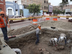 FILE - Archaeologists excavate ancient bones and vessels from a previous Inca culture that were discovered by city workers digging a natural gas line in the Brena neighborhood of Lima, Peru, Feb. 11, 2020. About 300 archaeological finds, some 2,000 years old, have been reported over the past decade during the building of thousands of kilometers (miles) of natural gas pipelines in the capital.