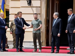 FILE - German Chancellor Olaf Scholz, left, watches Ukrainian President Volodymyr Zelenskyy shakes hands with French President Emmanuel Macron, second left, as Romanian President Klaus Iohannis, right, and Italian Prime Minister Mario Draghi look on before a meeting in Kyiv, Thursday, June 16, 2022. Seven decades after it was founded, the North Atlantic Treaty Organization is meeting in Madrid on June 29 and 30, 2022 with an urgent need to reassert its original mission: preventing Russian aggression against Western allies.