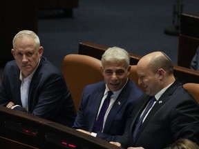 Israeli Defence Minister Benny Gantz, left, Foreign Minister Yair Lapid, center, and Prime Minister Naftali Bennett attend a preliminary vote on a bill to dissolve parliament, at the Knesset, Israel's parliament, in Jerusalem, Wednesday, June 22, 2022. Lawmakers voted in favor of dissolving parliament in a preliminary vote, setting the wheels in motion to send the country to its fifth national election in just over three years. Once it passes, Bennett will step down as prime minister and hand over the reins to his ally, Lapid. New elections are expected to be held in October.