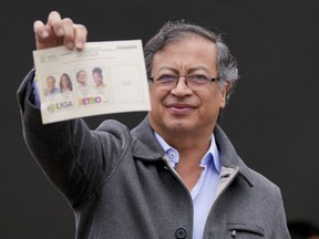 Gustavo Petro, presidential candidate with the Historical Pact coalition, shows his ballot before voting in a presidential runoff in Bogota, Colombia, Sunday, June 19, 2022.
