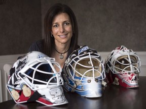 Manon Rheaume poses for a photograph with three of her masks Wednesday, November 2, 2016 in Detroit. The Los Angeles Kings have hired the former star goaltender to a front office position, furthering the recent trend of women landing high-profile jobs with NHL teams.THE CANADIAN PRESS/Paul Chiasson