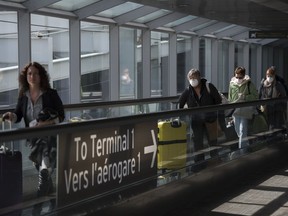 People leave after arriving at Pearson International Airport in Toronto on Monday, March 16, 2020. New COVID-19 testing rules came into effect in Canada Tuesday.THE CANADIAN PRESS/Nathan Denette