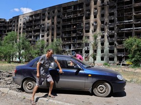 Local residents get into a car in front of an apartment building heavily damaged during Ukraine-Russia conflict in the city of Sievierodonetsk in the Luhansk Region, Ukraine July 1, 2022.