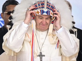 Pope Francis wears a headdress presented to him by Indigenous leaders during a visit to Maskwacis, Alta., on July 25, 2022.