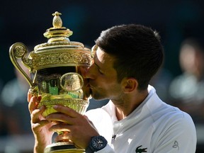 Serbia's Novak Djokovic celebrates with the trophy after winning the men's singles final against Australia's Nick Kyrgios.