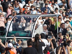 Papst Franziskus küsst ein Baby, bevor er während seines Besuchs in Edmonton, Alberta, Kanada, am 26. Juli 2022 eine Messe im Commonwealth Stadium feiert.