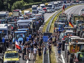 Farmers gather with their vehicles next to a Germany/Netherlands border sign during a protest on the A1 highway, near Rijssen, on June 29, 2022, against the Dutch Government's nitrogen plans. (Photo by Vincent Jannink / ANP / AFP)