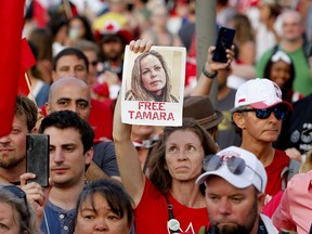 A woman holds a photograph of Tamara Lich, one of the main  organizers of the Freedom Convoy, as a protest against COVID-19 mandates takes place in Ottawa on Canada Day, July 1, 2022.